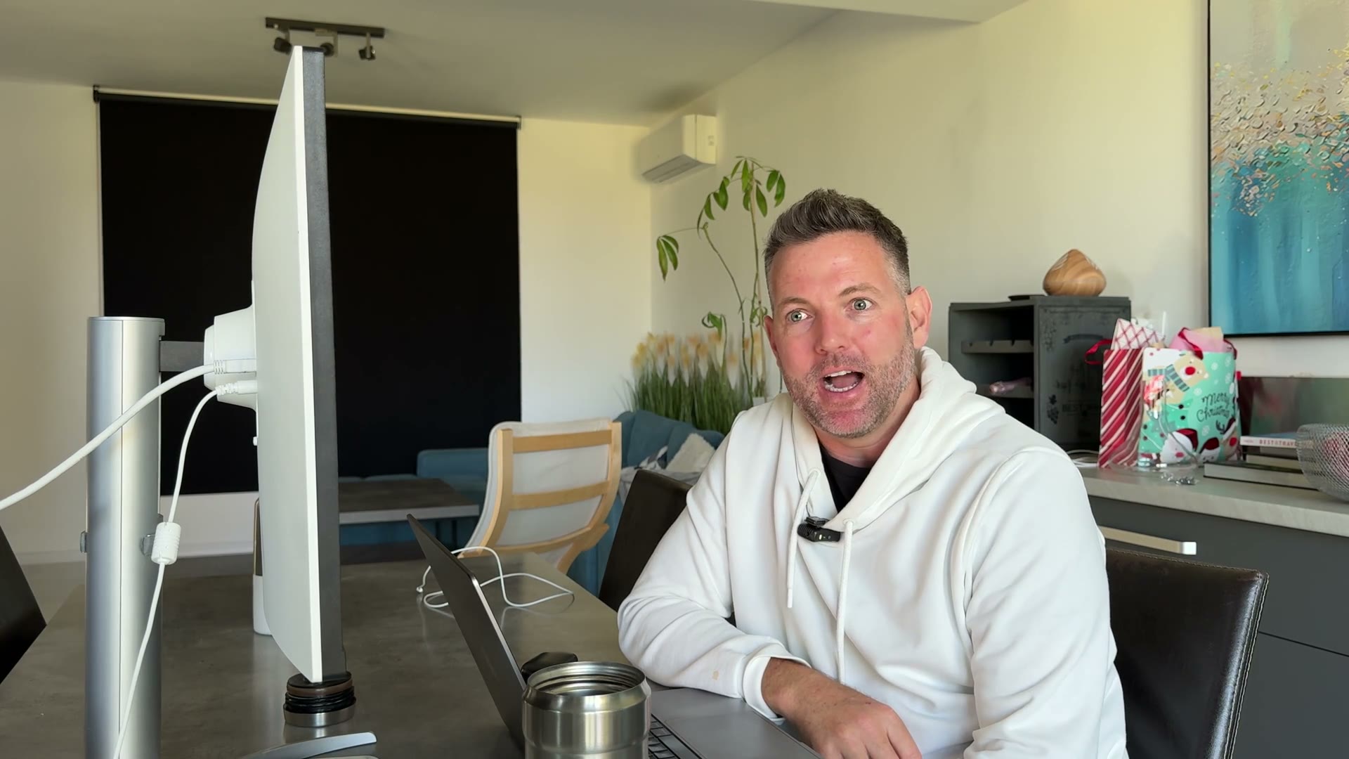 Nick sitting at a desk with a monitor and laptop, talking to camera