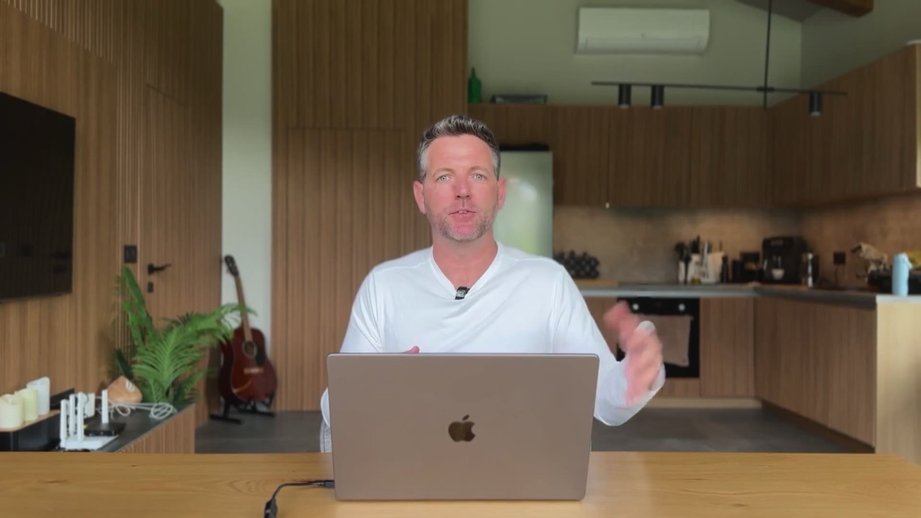 Nick sitting at his kitchen table talking to camera with a laptop in front of him
